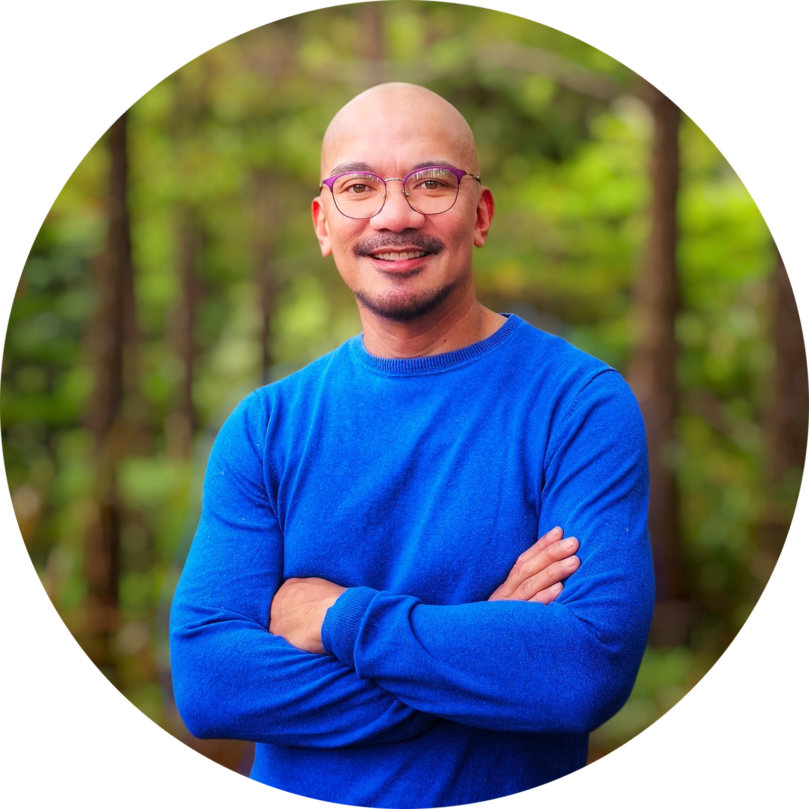 Jon Encarnacion, standing outdoors with arms crossed, smiling